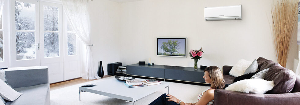 Woman relaxing in a bright Christchurch lounge kept comfortable by a wall-mounted heat pump installed by Southern Comfort Air Conditioning